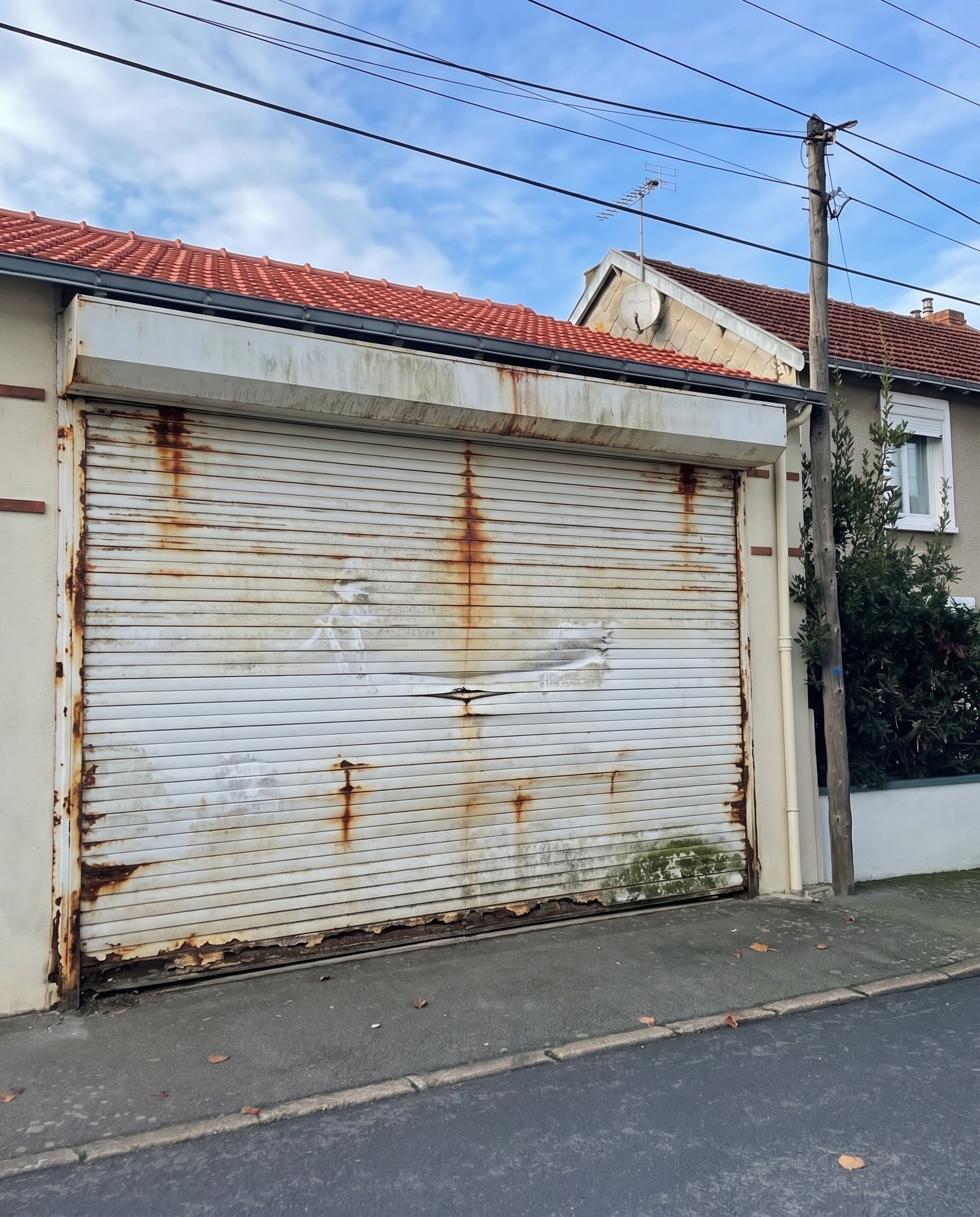 Volet roulant de garage rouillé et abîmé avant remplacement