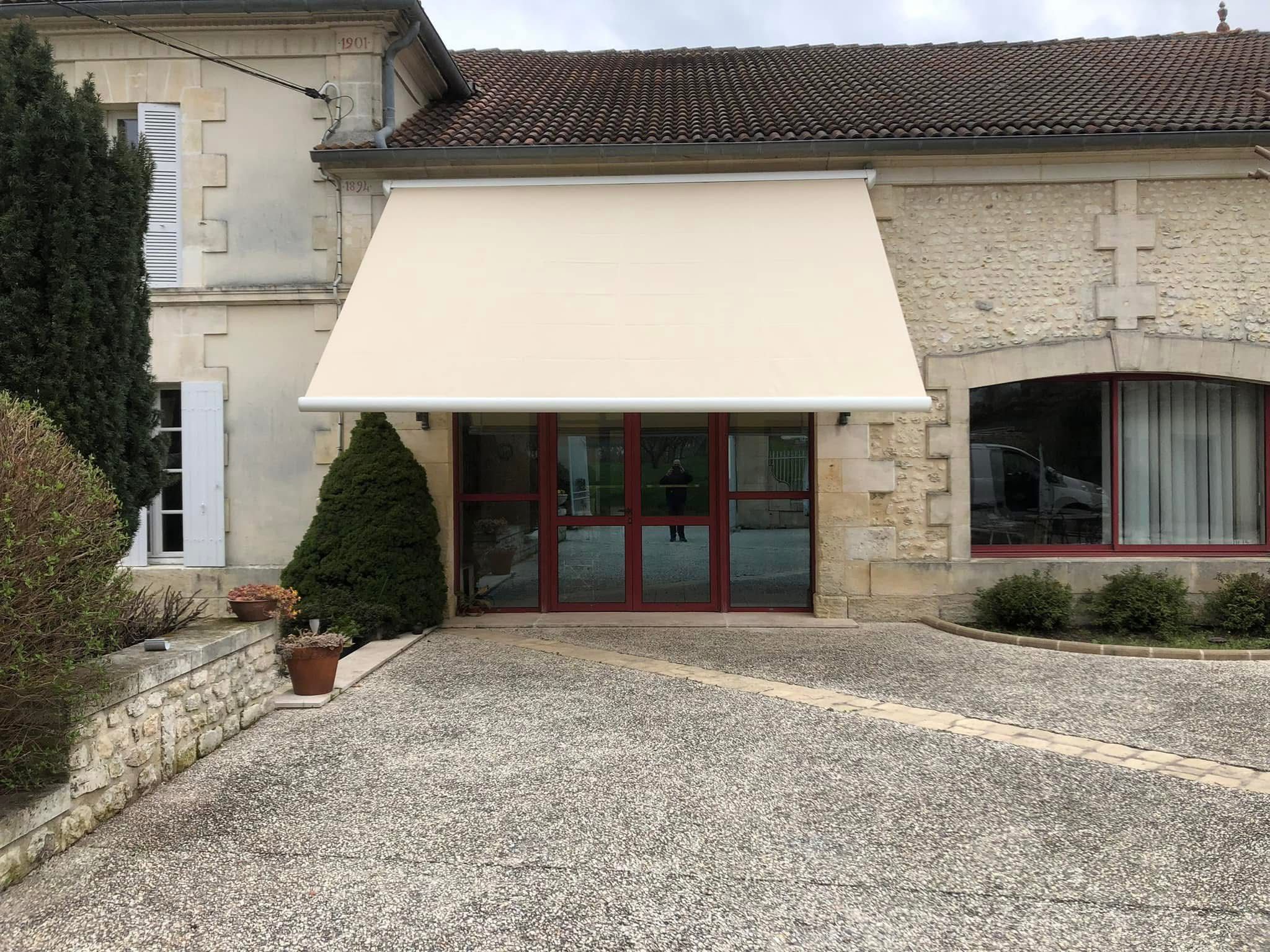 Store banne écru posé sur une maison en pierre