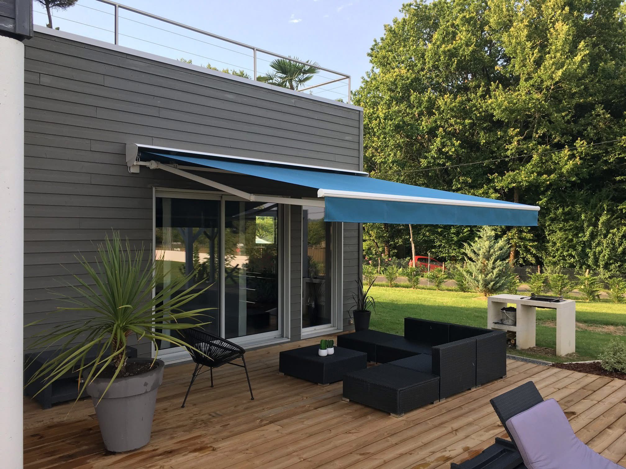 Store banne bleu sur la terrasse d'une maison contemporaine